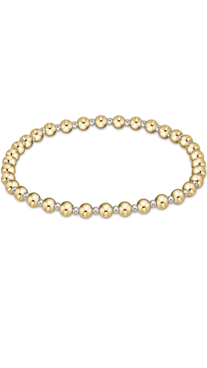 A stretch bracelet made of alternating polished gold and matte silver round beads, displayed horizontally on a clean white background.
