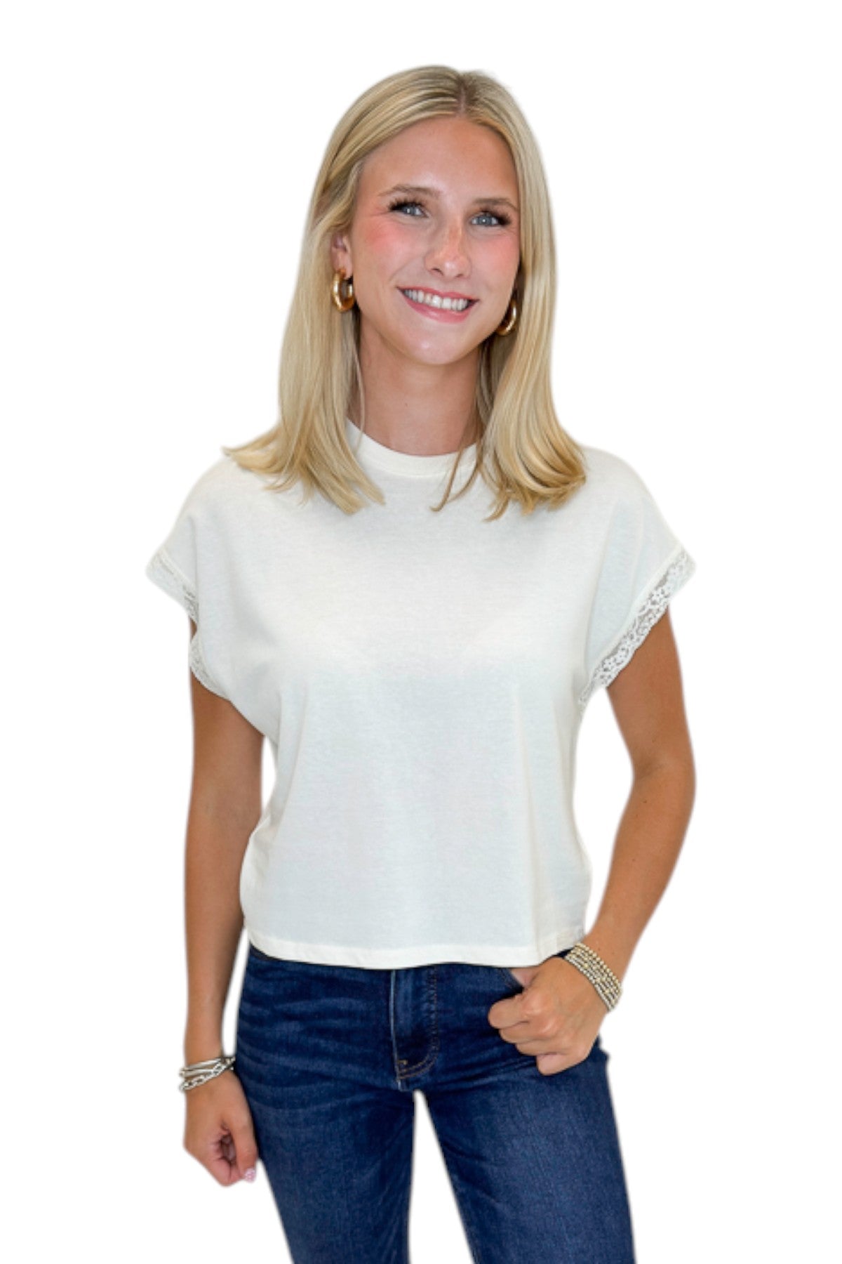 Front view of woman wearing Swagger Boutique’s Cloud Marika Lace Trim Muscle Tee by Z Supply with jeans against white studio background.