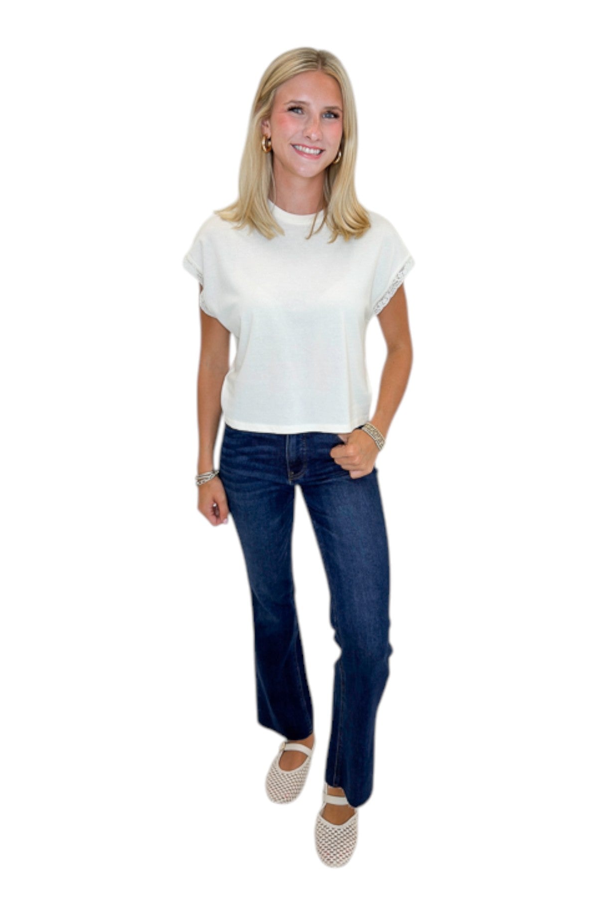 Front view of woman wearing Swagger Boutique’s Cloud Marika Lace Trim Muscle Tee by Z Supply with jeans against white studio background.