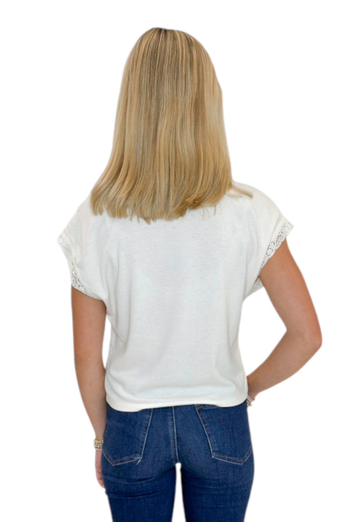 Back view of woman wearing Swagger Boutique’s Cloud Marika Lace Trim Muscle Tee by Z Supply with jeans against white studio background.