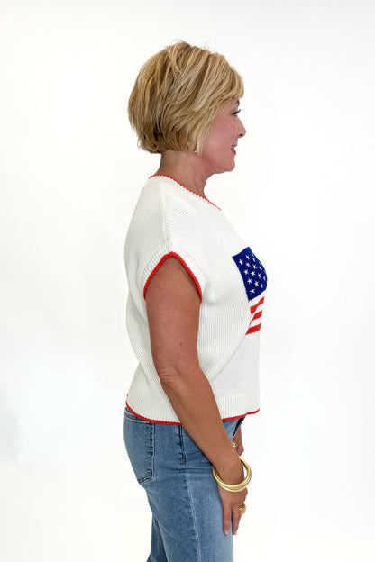 Side view of woman wearing Swagger Boutique’s  Sleeveless Patriot Sweater In Cloud by Z Supply with jeans and sandals against white studio background.