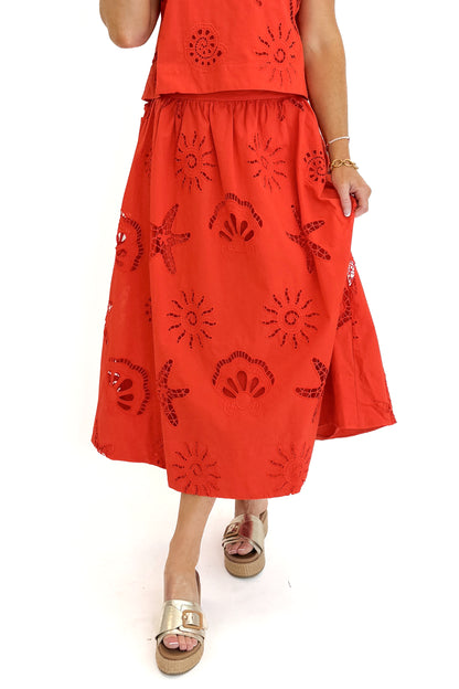 Front detail view of woman wearing Swagger Boutique’s Coral Shell Embroidered Tank with matching Coral Shell Embroidered Midi Skirt against white studio background.