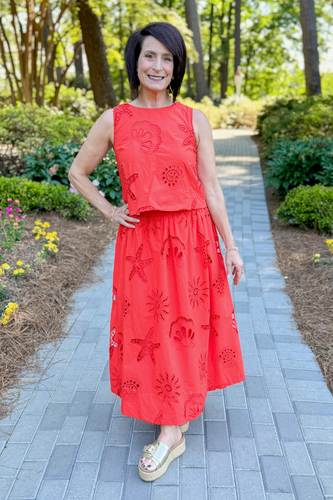 Front view of woman wearing Swagger Boutique’s Coral Shell Embroidered Tank with matching Coral Shell Embroidered Midi Skirt outside at a park.