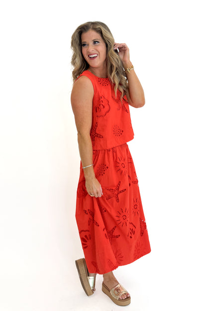 Side view of woman wearing Swagger Boutique’s Coral Shell Embroidered Tank with matching Coral Shell Embroidered Midi Skirt against white studio background.