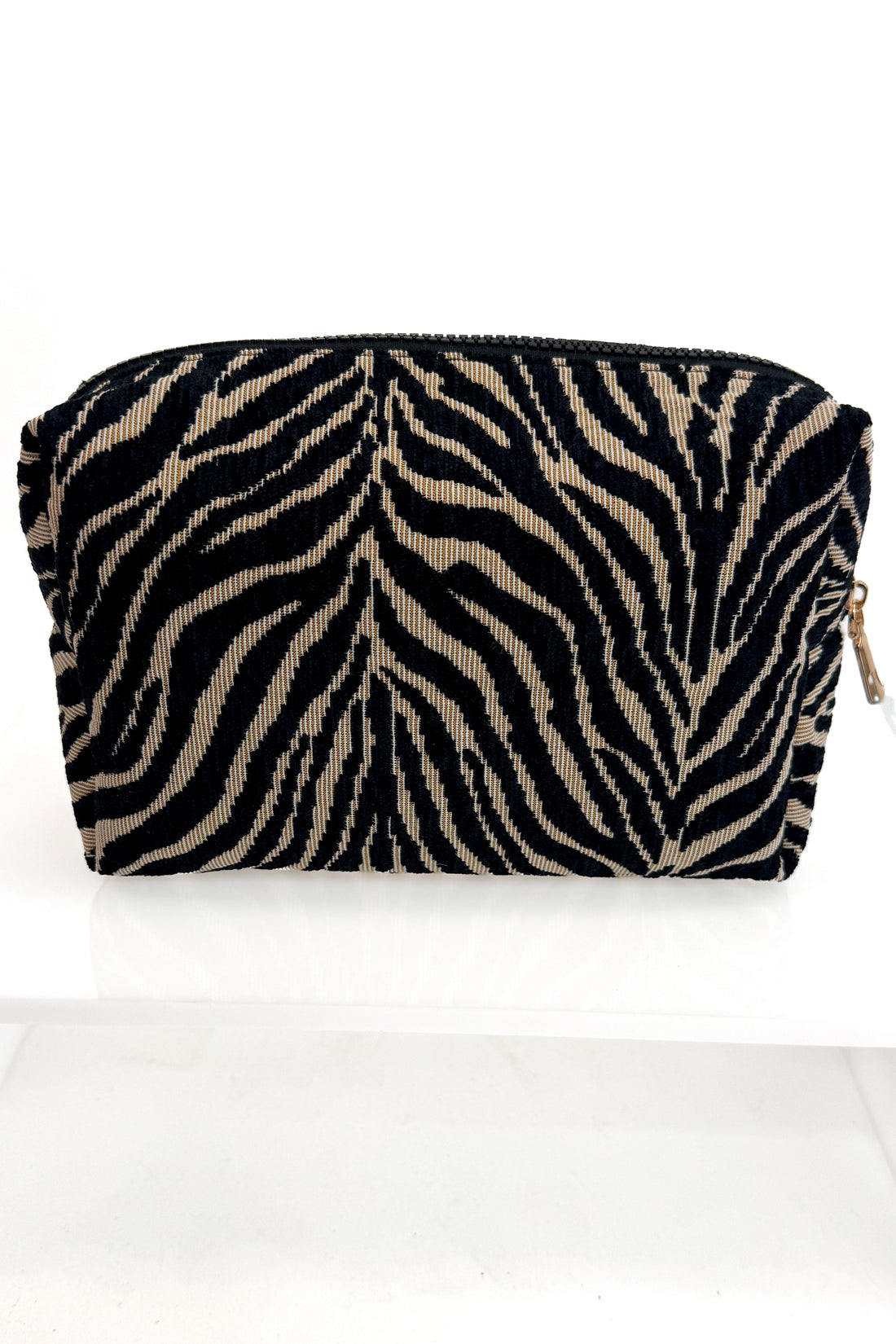 A small zippered pouch with a black and beige zebra stripe pattern, shown on a plain white background.