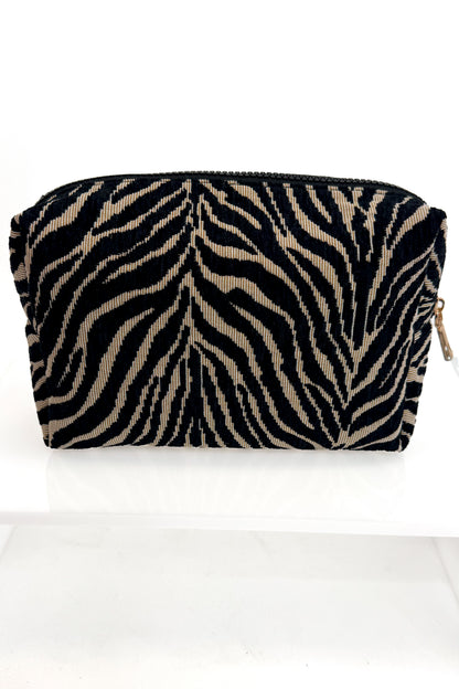 A small zippered pouch with a black and beige zebra stripe pattern, shown on a plain white background.