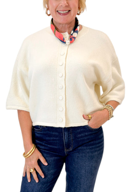 Front detail view of woman wearing Swagger Boutique’s Cream Button Down Short Sleeve Sweater by PINCH with jeans against white studio background.