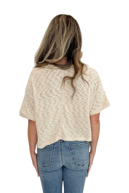 Back view of woman wearing Swagger Boutique’s Cream Button Up Short Sleeve Sweater with jeans against white studio background.