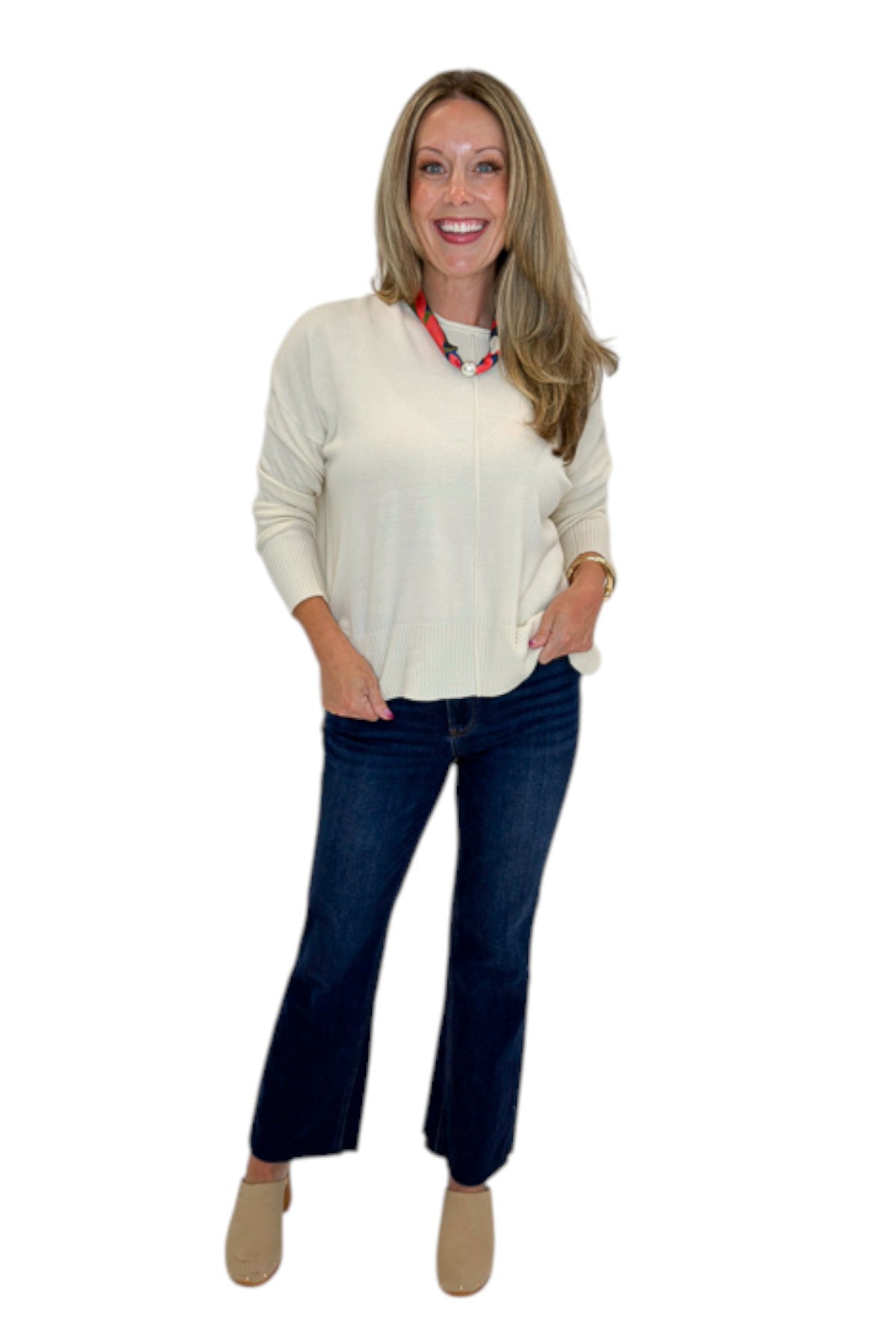 Front view of woman wearing Swagger Boutique’s Cream Center Seam Round Neck Sweater with jeans against white studio background.