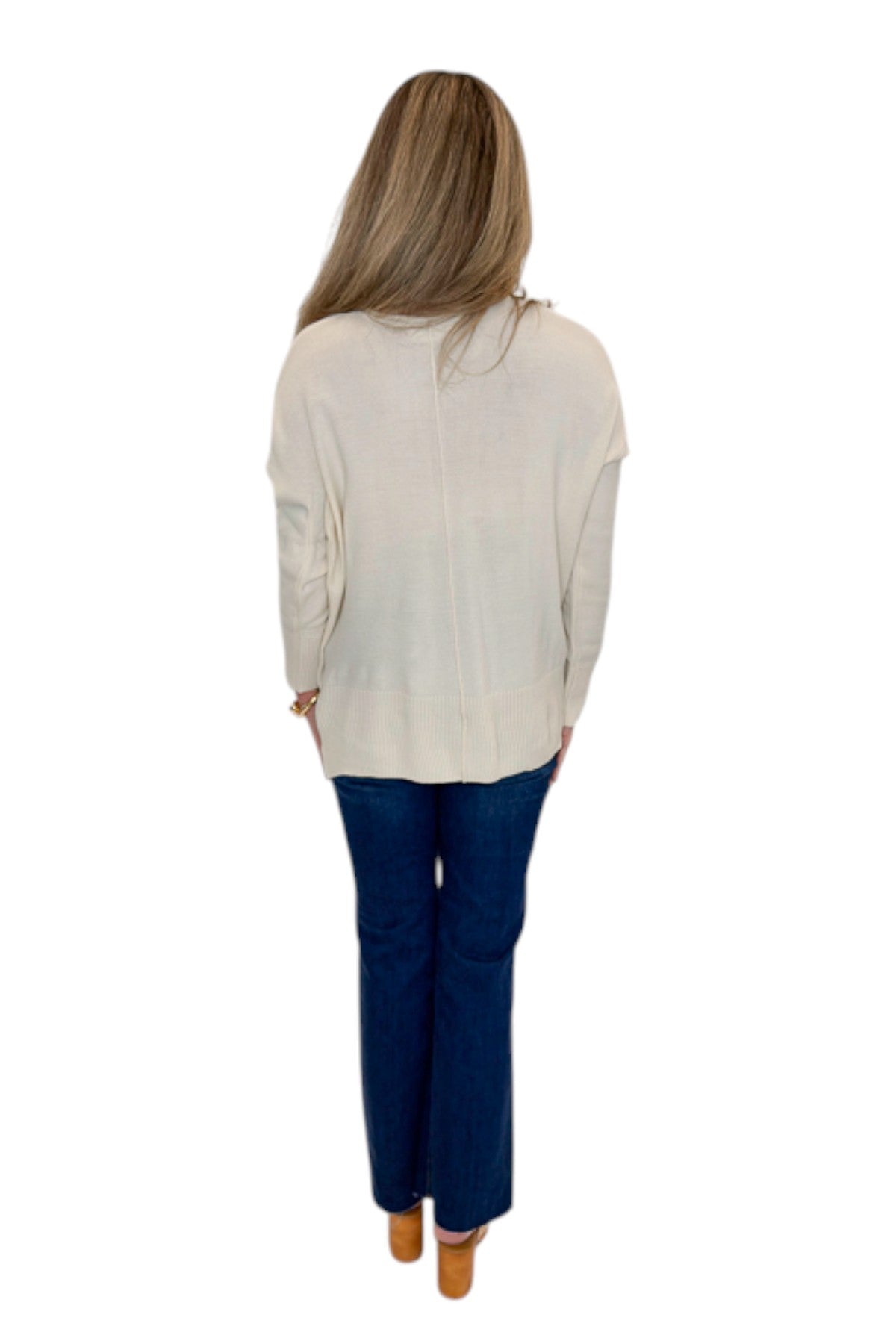 Back view of woman wearing Swagger Boutique’s Cream Center Seam Round Neck Sweater with jeans against white studio background.