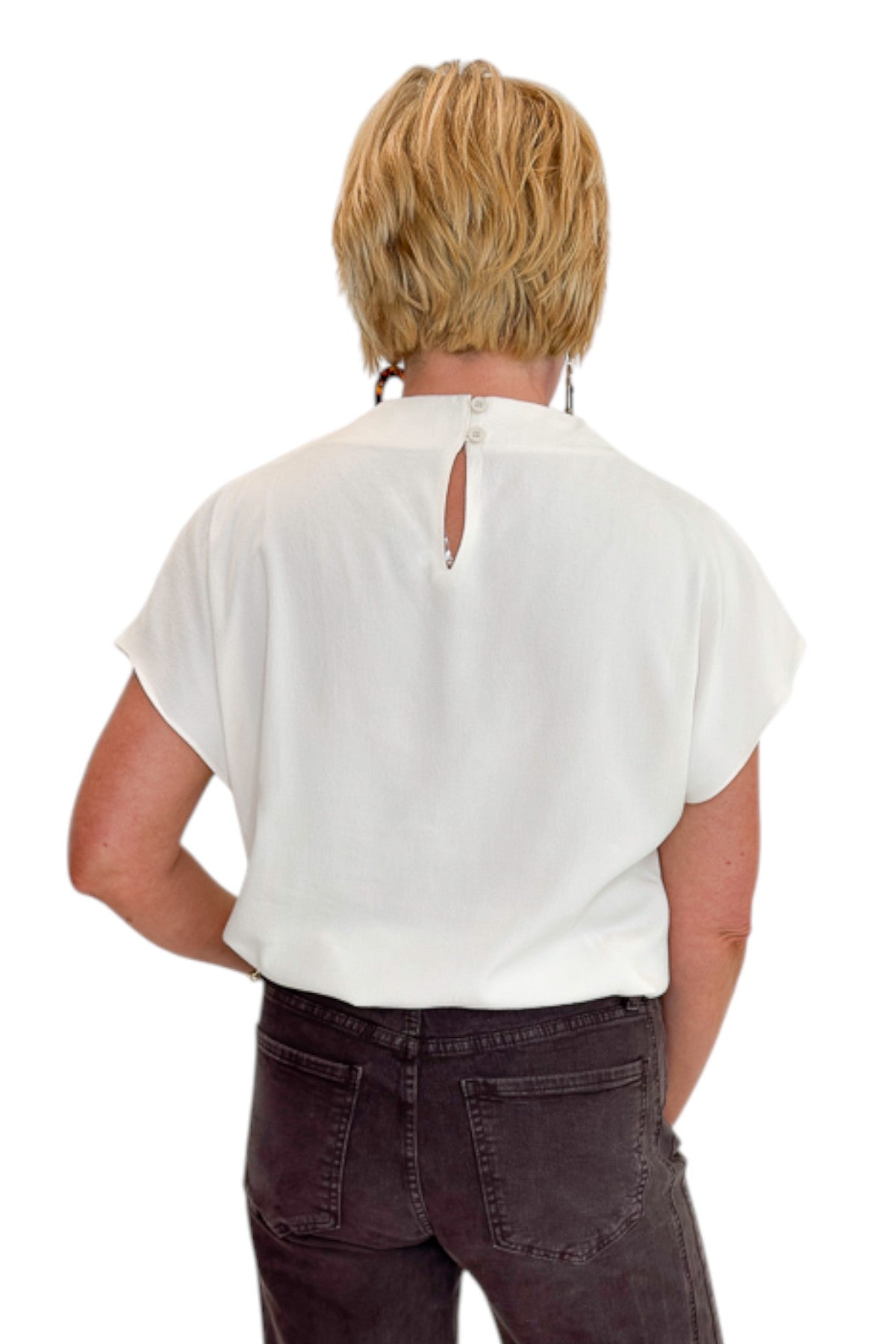 Back view of woman wearing Swagger Boutique’s Cream Cowl Neck Top with jeans against white studio background.