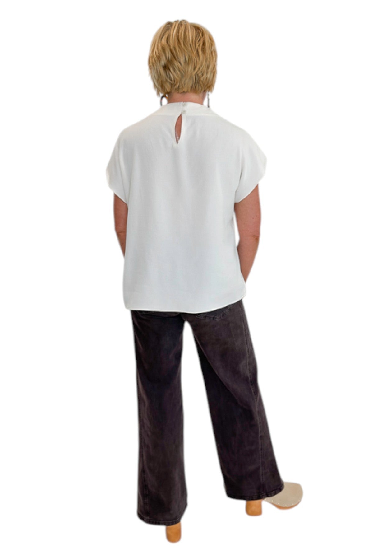 Back view of woman wearing Swagger Boutique’s Cream Cowl Neck Top with jeans against white studio background.