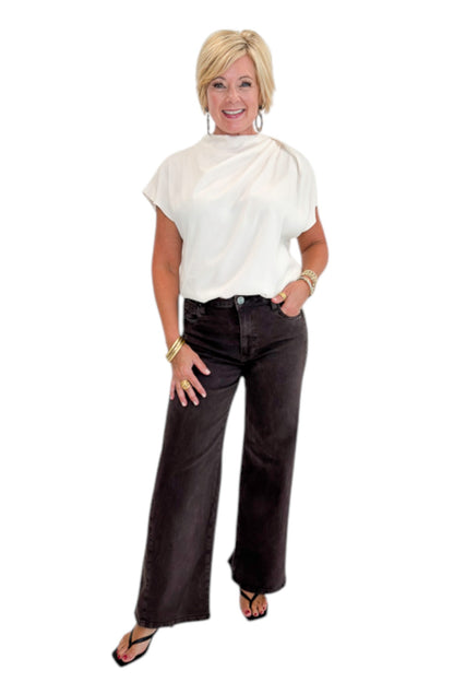 Front view of woman wearing Swagger Boutique’s Cream Cowl Neck Top with jeans against white studio background.