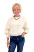 Front view of woman wearing Swagger Boutique’s Cream Elastic Hem Sweatshirt with jeans against white studio background.