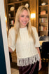 Front view of woman wearing Swagger Boutique’s Wine Satin Maxi Skirt with Cream Fringe Short Sleeve Sweater standing outside a den.