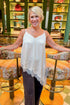 Front view of woman wearing Swagger Boutique’s Cream Lace Asymmetrical Tank with jeans at a bar and lounge.