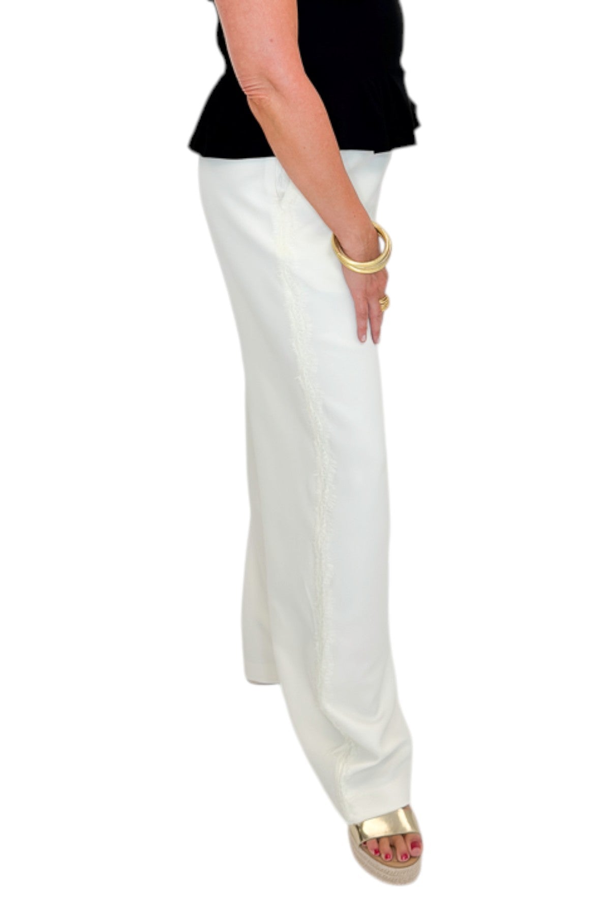 Side view of woman wearing Swagger Boutique’s Cream Lace Lined Pants with top against white studio background.