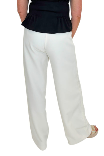 Back view of woman wearing Swagger Boutique’s Cream Lace Lined Pants with top against white studio background.