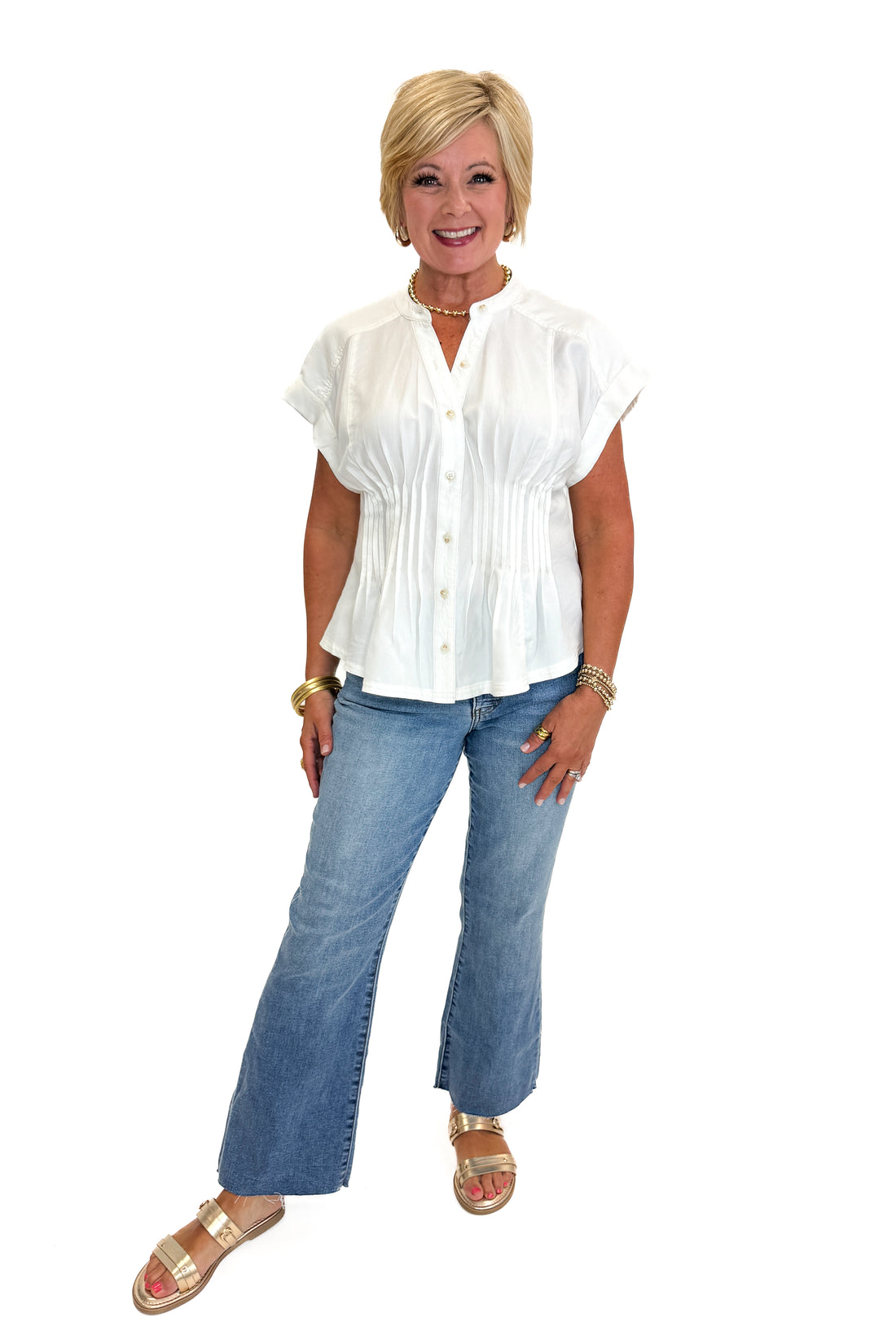 Front view of woman wearing Swagger Boutique’s Cream Pintuck Waist Top with jeans against white studio background.