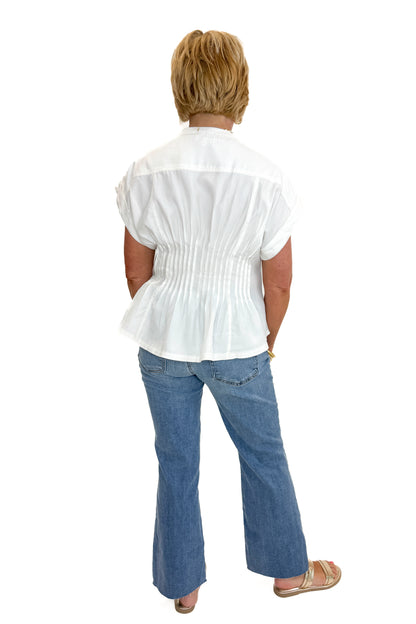 Back view of woman wearing Swagger Boutique’s Cream Pintuck Waist Top with jeans against white studio background.