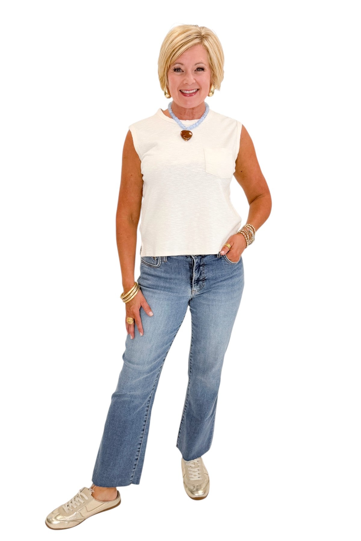 Front view of woman wearing Swagger Boutique’s Cream Pocket Detail Tank with jeans against white studio background.
