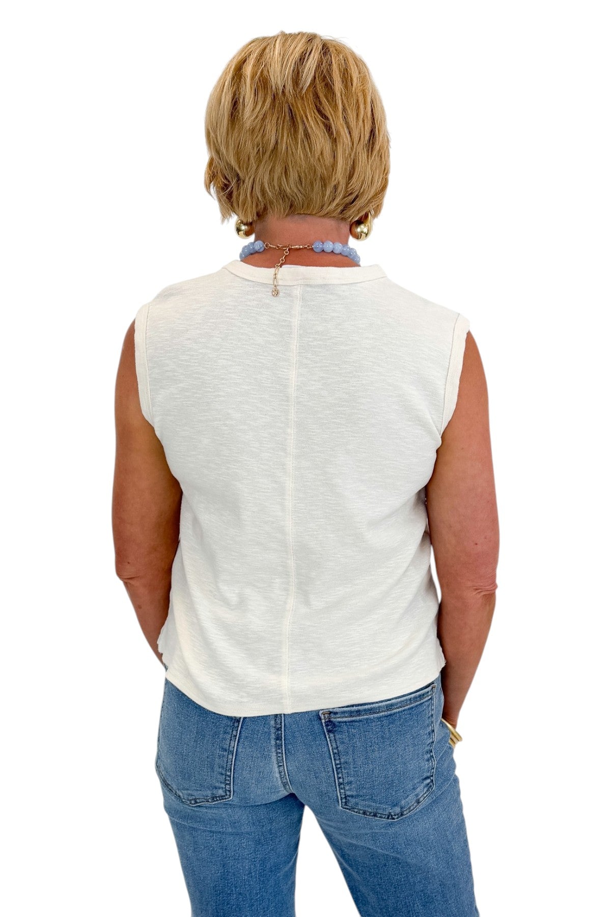 Back view of woman wearing Swagger Boutique’s Cream Pocket Detail Tank with jeans against white studio background.