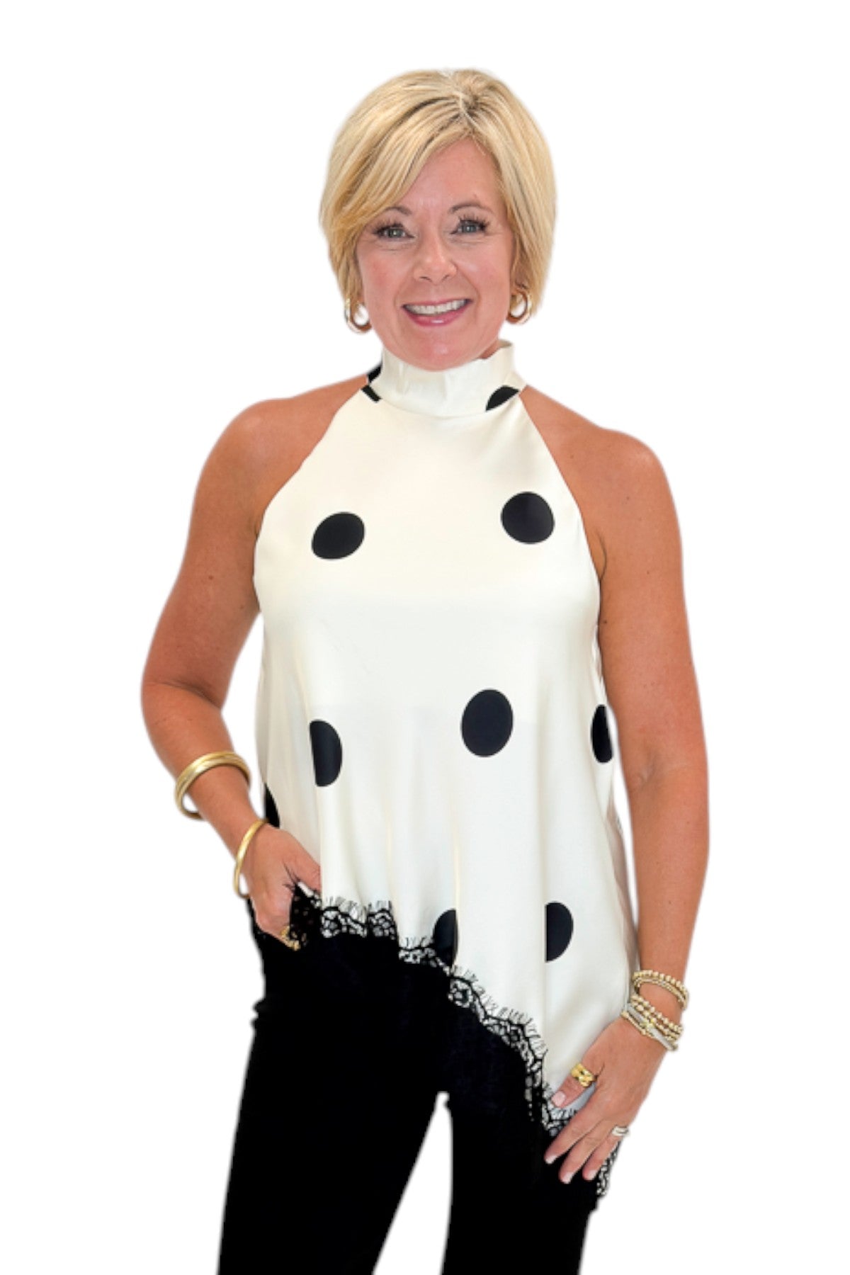 Front view of woman wearing Swagger Boutique’s Cream Polka Dot Asymmetrical Halter Neck Satin Lace Top by Entro with jeans against white studio background.