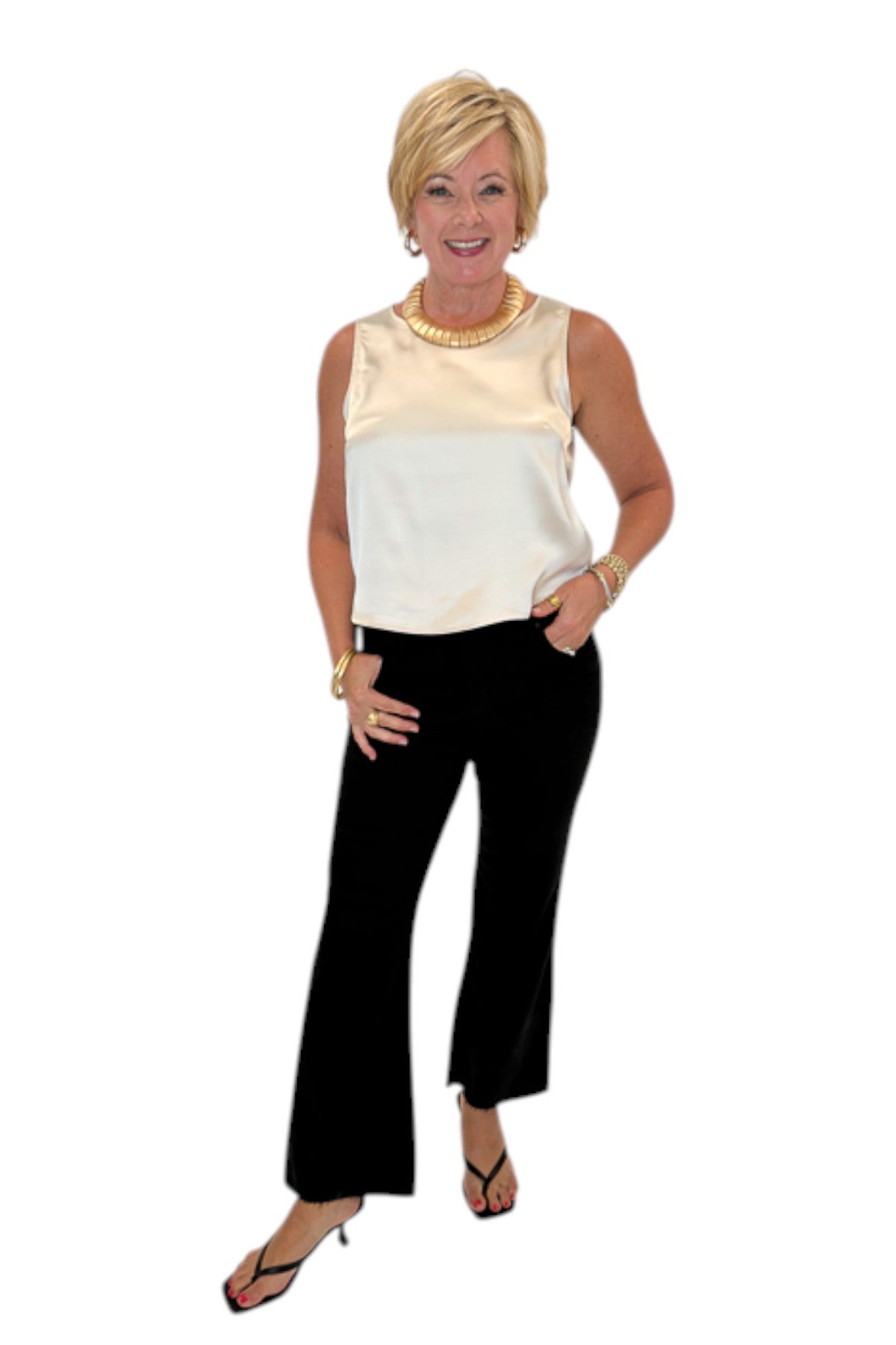 Front view of woman wearing Swagger Boutique’s cream satin tank with jeans against white studio background.