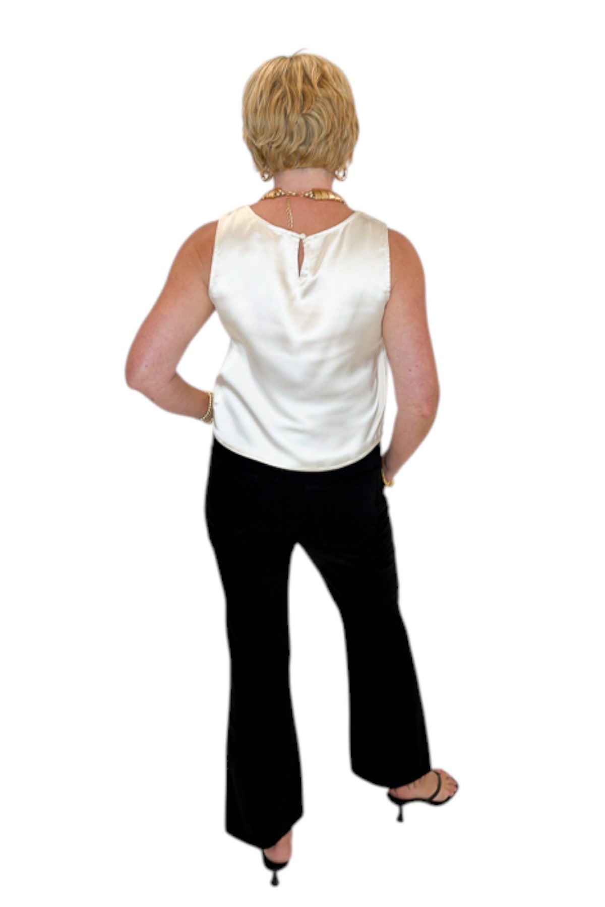 Back view of woman wearing Swagger Boutique’s cream satin tank with jeans against white studio background.