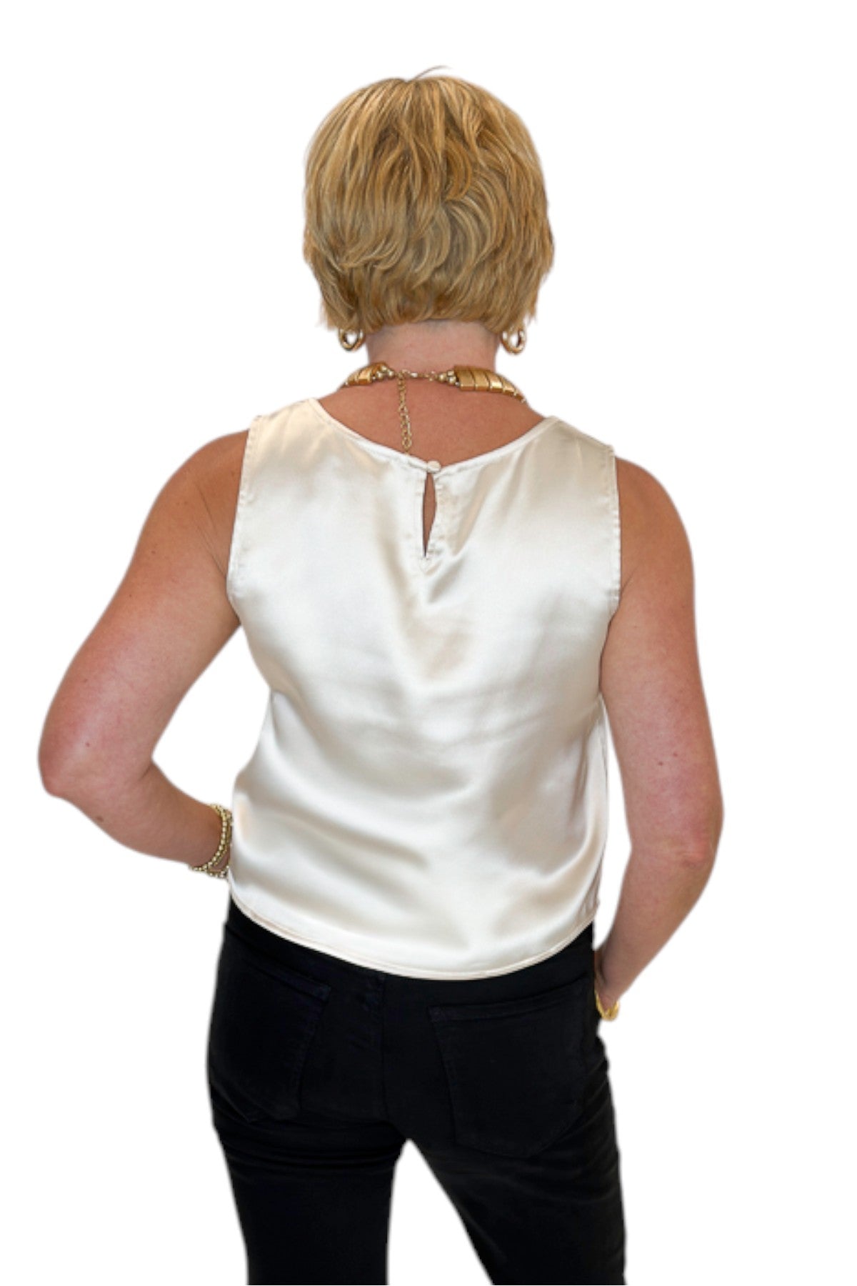 Back view of woman wearing Swagger Boutique’s cream satin tank with jeans against white studio background.