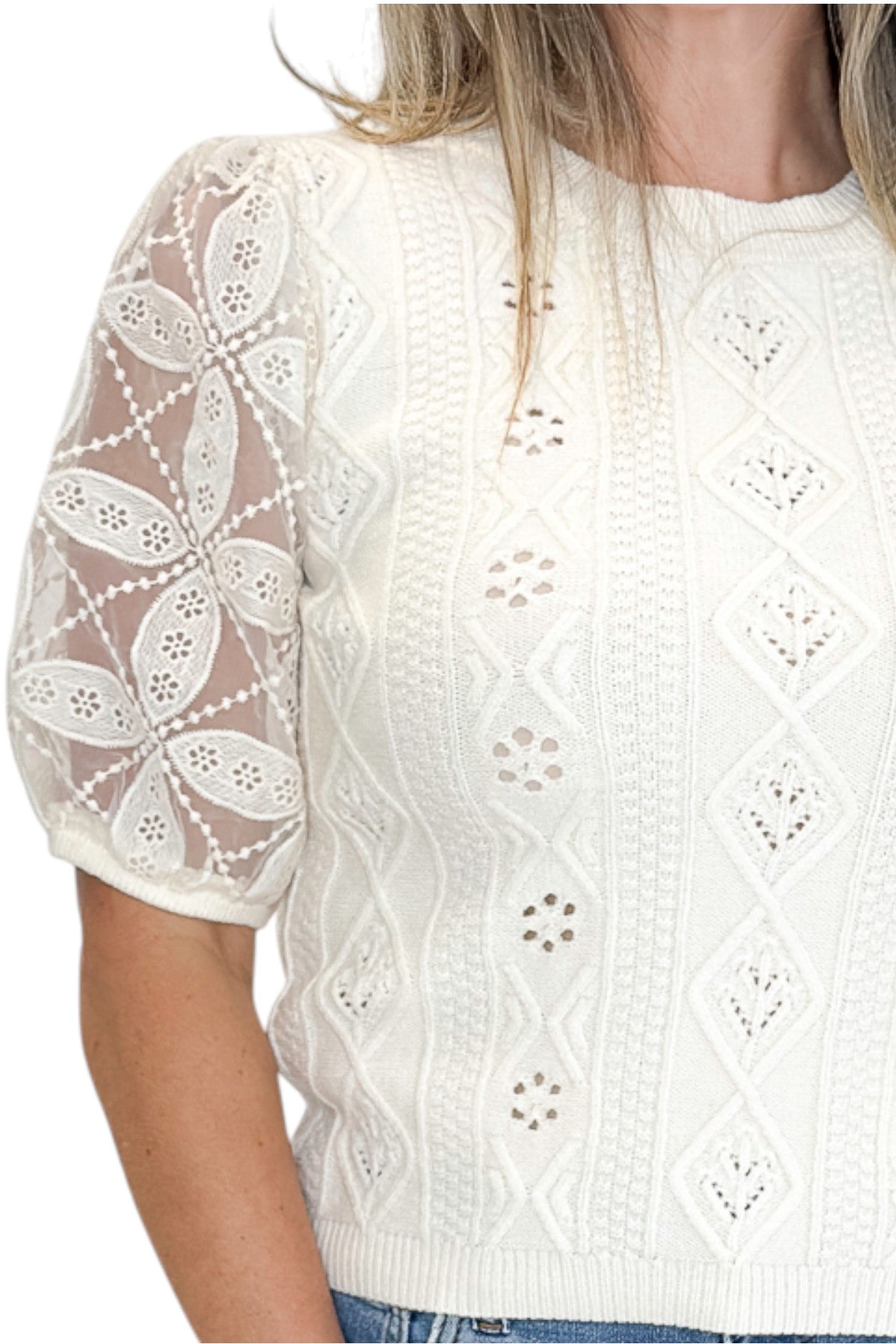 Front detail view of woman wearing Swagger Boutique’s Cream Sheer Sleeve Sweater with jeans against white studio background.