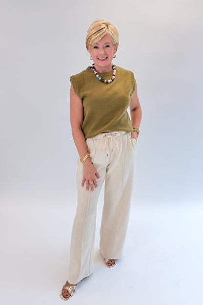 Front view of woman wearing Swagger Boutique’s Cream Suede Pants with sweater against white studio background.