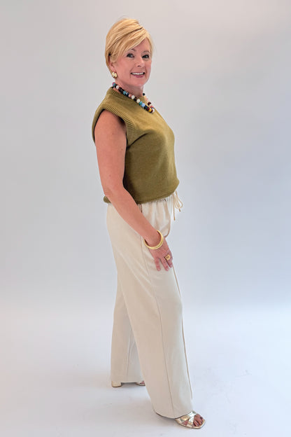 Side view of woman wearing Swagger Boutique’s Cream Suede Pants with sweater against white studio background.