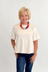 Front view of woman wearing Swagger Boutique’s Cream Suede Swing Top with jeans against white studio background.