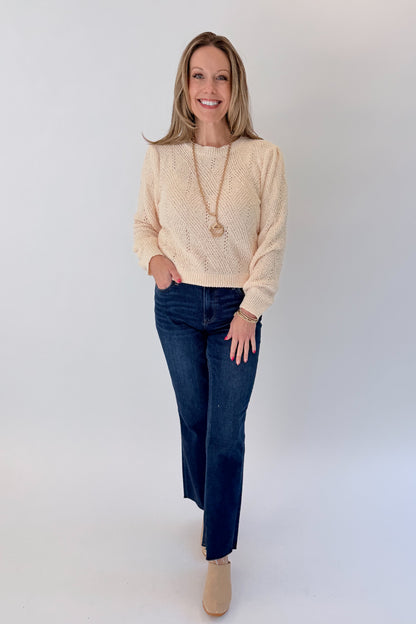 Front view of woman wearing Swagger Boutique’s Cream Textured Crew Neck Sweater with jeans against white studio background.