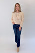 Front view of woman wearing Swagger Boutique’s Cream Textured Crew Neck Sweater with jeans against white studio background.