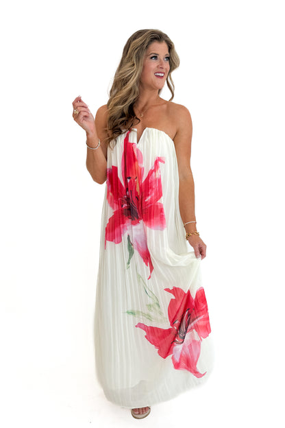 Front view of woman wearing Swagger Boutique’s Cream With Large Floral Print Pleat Detail Maxi Dress with sandals against white studio background.