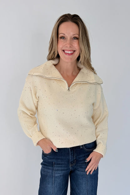 Front view of woman wearing Swagger Boutique’s Cream With Multi Sequins Sweater with jeans against white studio background.