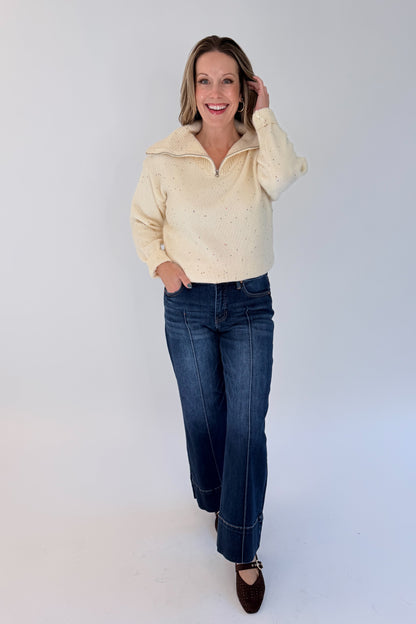 Front view of woman wearing Swagger Boutique’s Cream With Multi Sequins Sweater with jeans against white studio background.