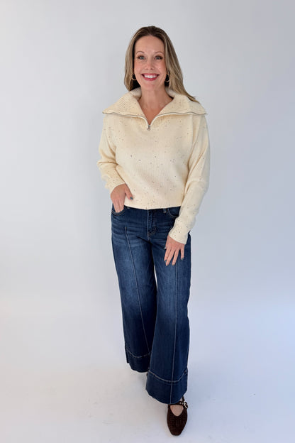 Front view of woman wearing Swagger Boutique’s Cream With Multi Sequins Sweater with jeans against white studio background.