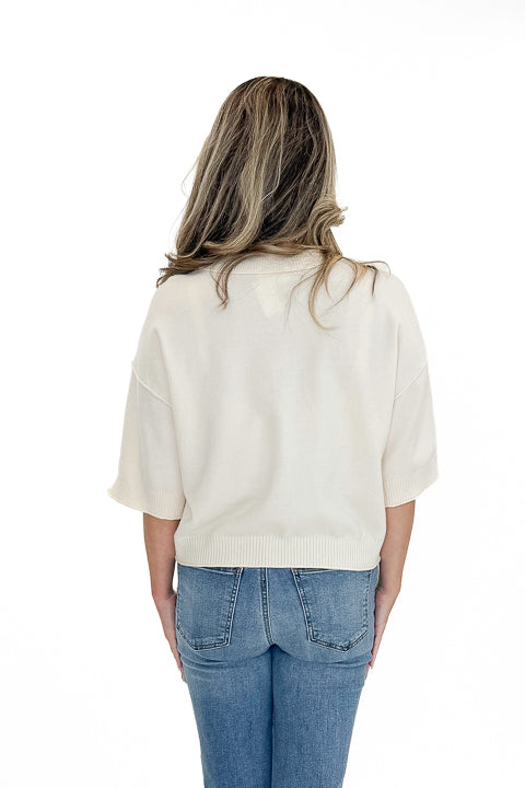 Back view of woman wearing Swagger Boutique’s Cream 3/4 Sleeve Lightweight Sweater by Entro with jeans against white studio background.