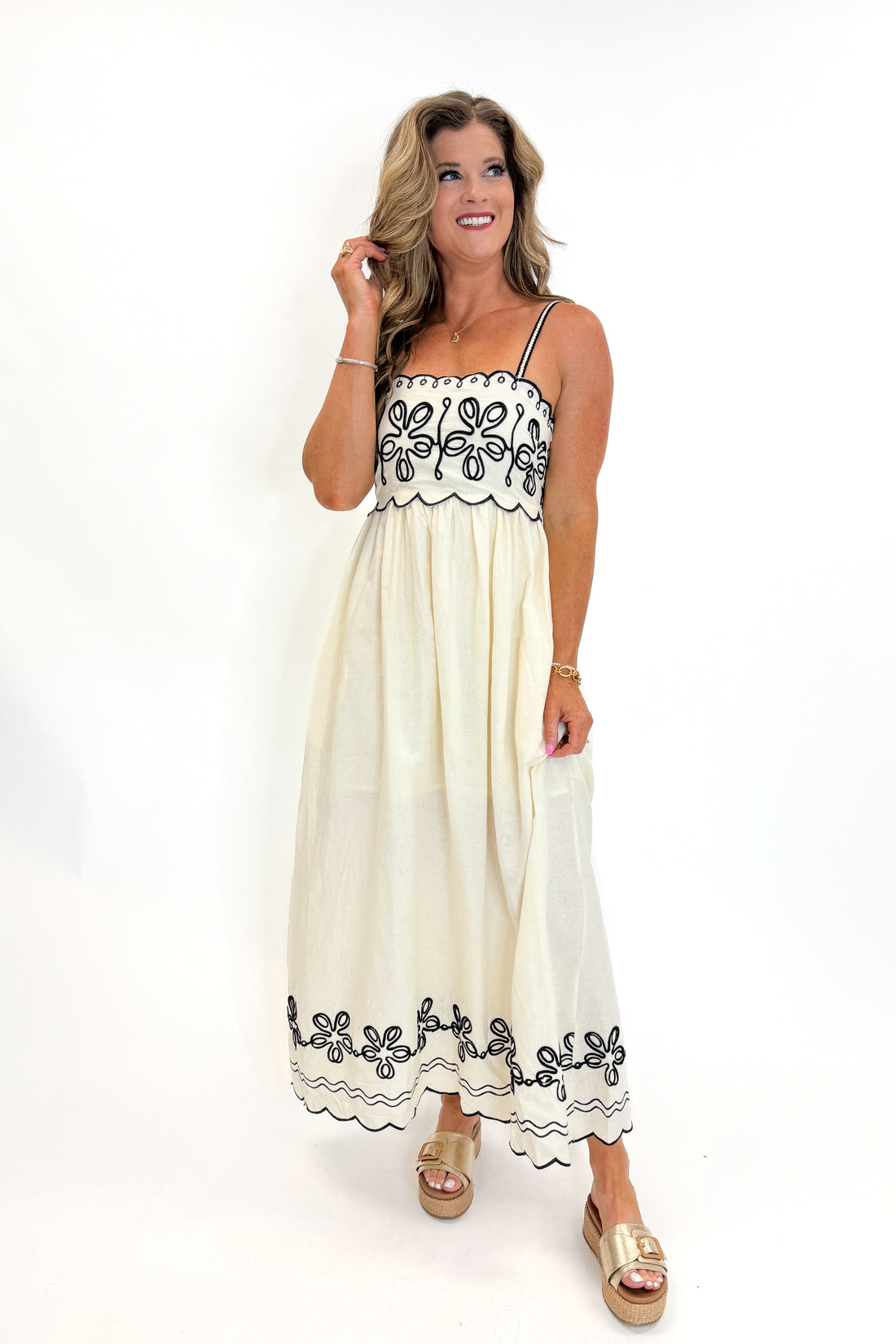 Front view of woman wearing Swagger Boutique’s Cream &amp; Black Embroidered Maxi Dress with sandals against white studio background.