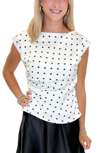Front detail view of woman wearing Swagger Boutique’s Cream &amp; Black Polka Dot Boat Neck Tank with Black Satin Mini Skirt against white studio background.