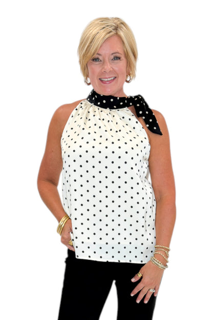 Front view of woman wearing Swagger Boutique’s Cream &amp; Black Polka Dot Halter Neck Tank with jeans against white studio background.