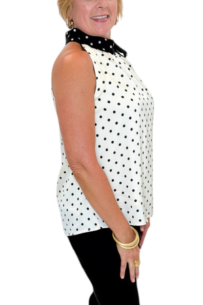 Side view of woman wearing Swagger Boutique’s Cream &amp; Black Polka Dot Halter Neck Tank with jeans against white studio background.