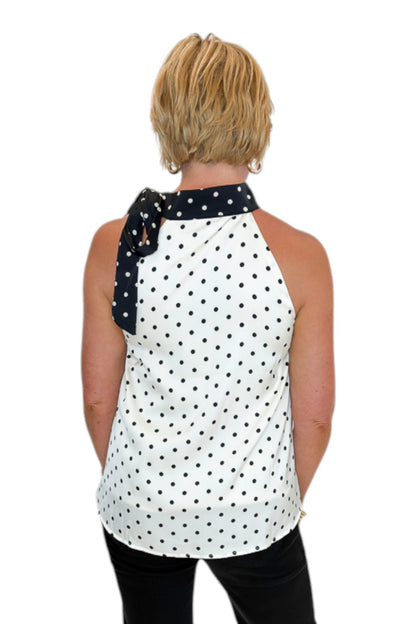 Back view of woman wearing Swagger Boutique’s Cream &amp; Black Polka Dot Halter Neck Tank with jeans against white studio background.