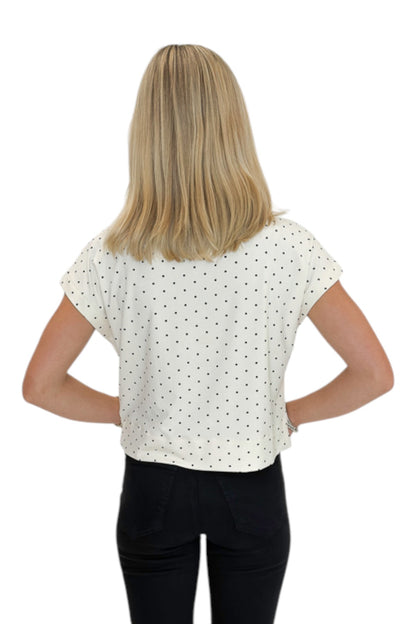 Back view of woman wearing Swagger Boutique’s Cream &amp; Black Polka Dot Mock Neck Top by Entro with jeans against white studio background.