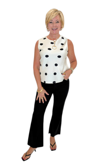 Front view of woman wearing Swagger Boutique’s Cream &amp; Black Polka Dot Satin Tank with jeans against white studio background.