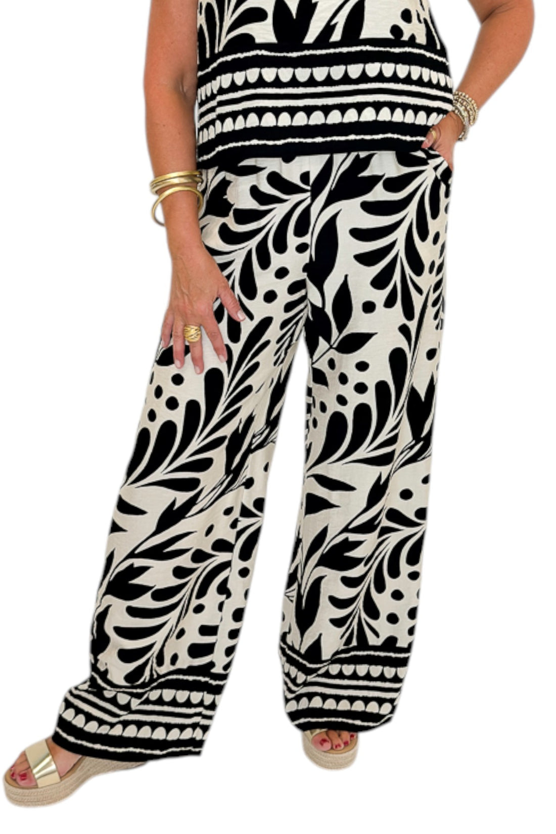 Front detail view of woman wearing Swagger Boutique’s Cream &amp; Black Printed Tank &amp; Wide Leg Pants against white studio background.