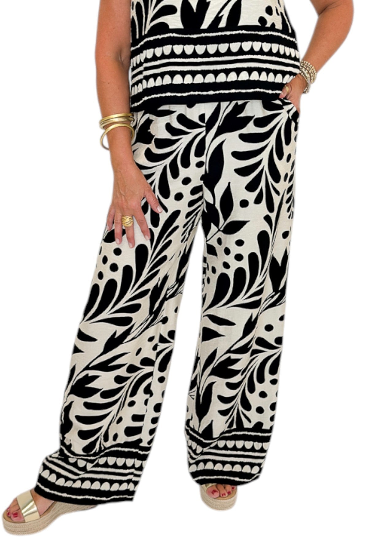 Front detail view of woman wearing Swagger Boutique’s Cream &amp; Black Printed Tank &amp; Wide Leg Pants against white studio background.